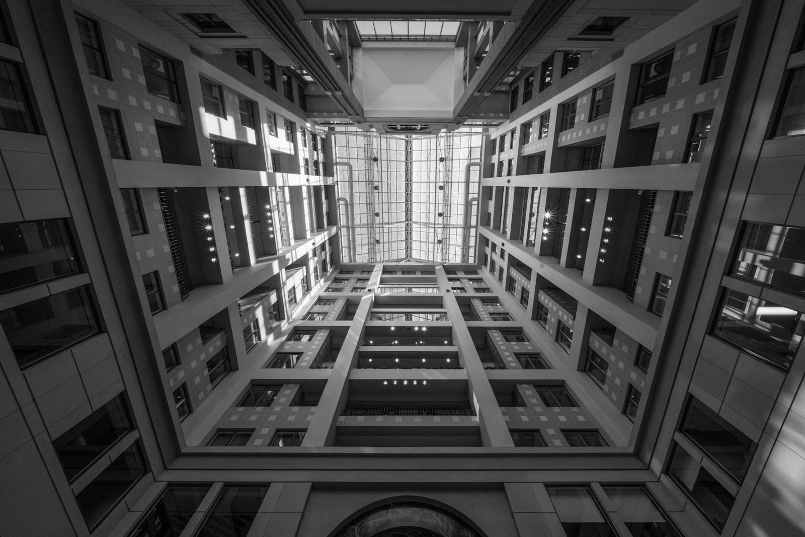 Looking up through a glass-roofed office atrium
