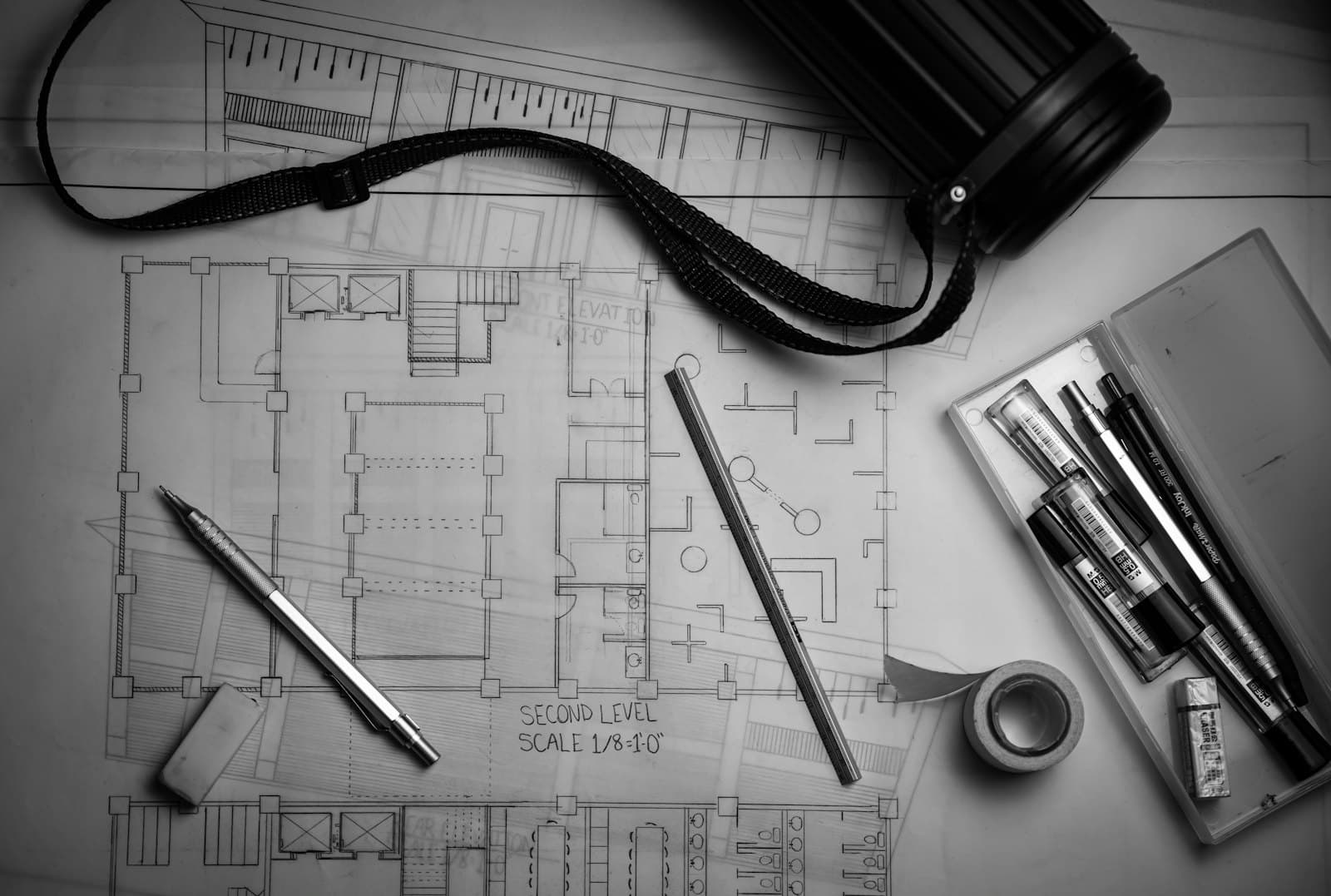 Architectural drawings and drafting pens on a desk