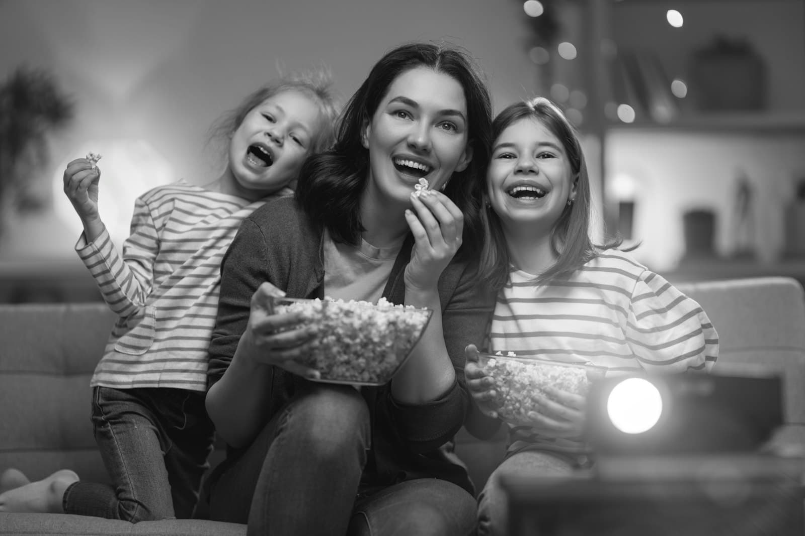 A family watching a movie with popcorn